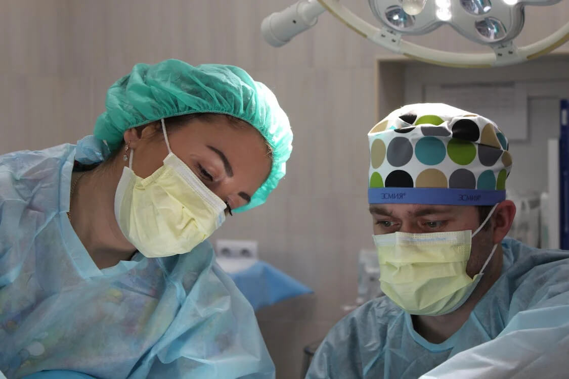 two surgeons perform labiaplasty surgery