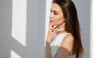 woman in white with finger touching lips