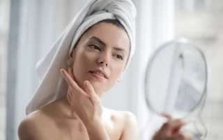 woman looking at face in mirror