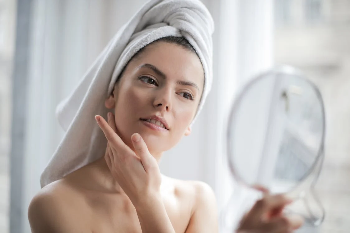femme regardant son visage dans le miroir
